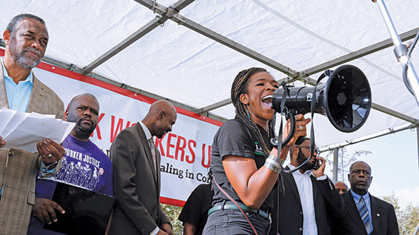 Black woman with a bullhorn at a workers' rights rally in Los Angeles