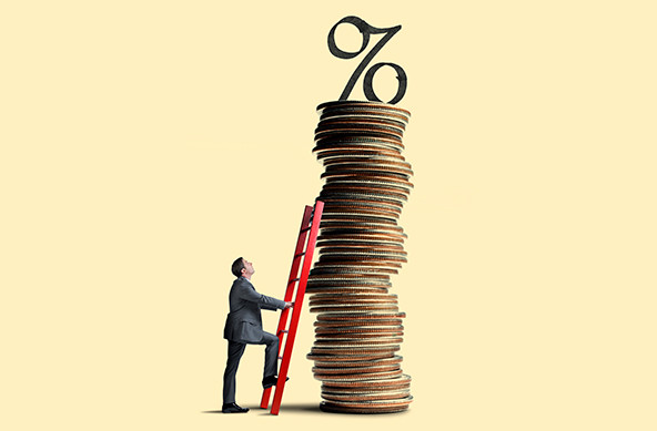 A man looks up as he leans a red ladder against a tall stack of coins that is topped with a percent symbol.