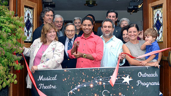 Photo of people standing behind a banner for Shining Stars Theater
