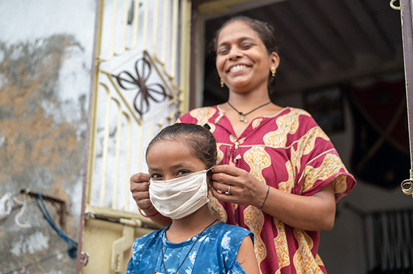 Young girl in India puts on a surgical mask during COVID-19 pandemic