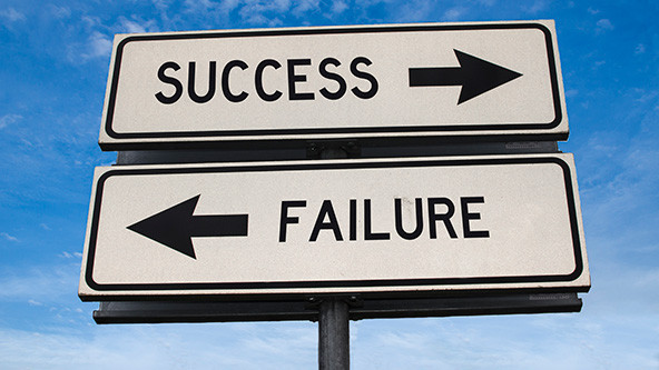 Two street signs with the words success and failure and arrows pointing in opposite directions