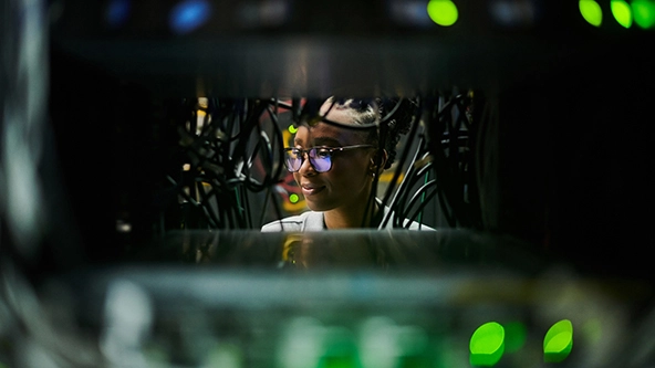 young female engineer working in a server room