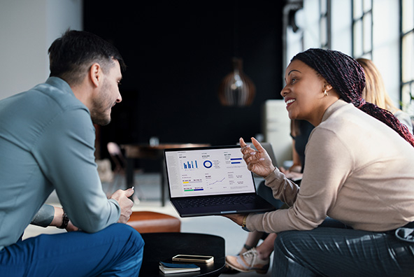 two people talking over a laptop