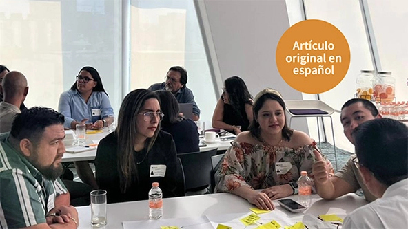 People sitting at long tables talking together