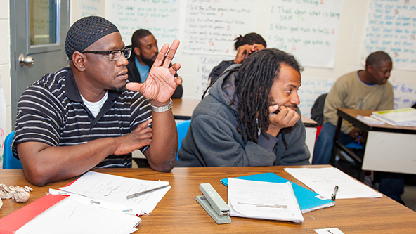 Two men sitting at a table in a classroom
