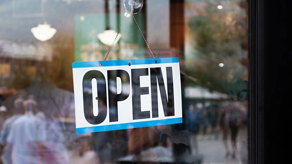 Open sign hanging in business window