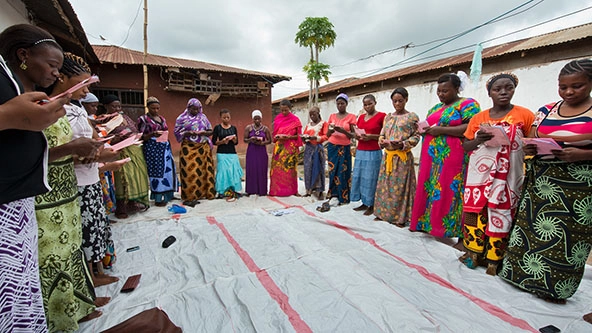 Women standing in a circle holding cell phones in Tanzania