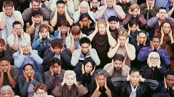 View of crowd covering ears