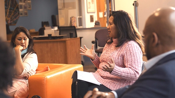 Woman speaking in a group of peers