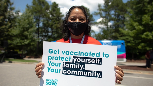 A woman holds a sign that reads 