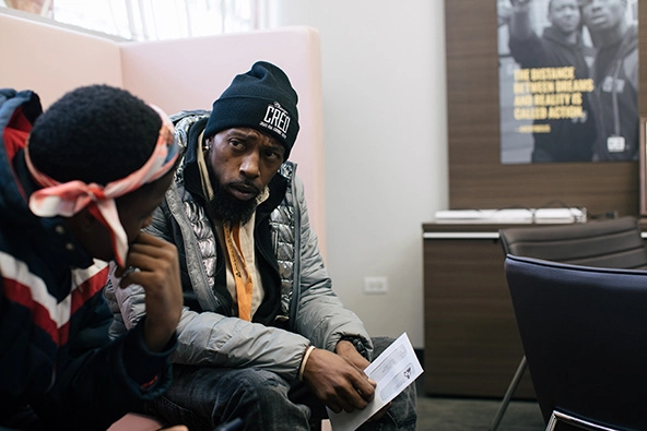 Two men sitting in a room and talking together