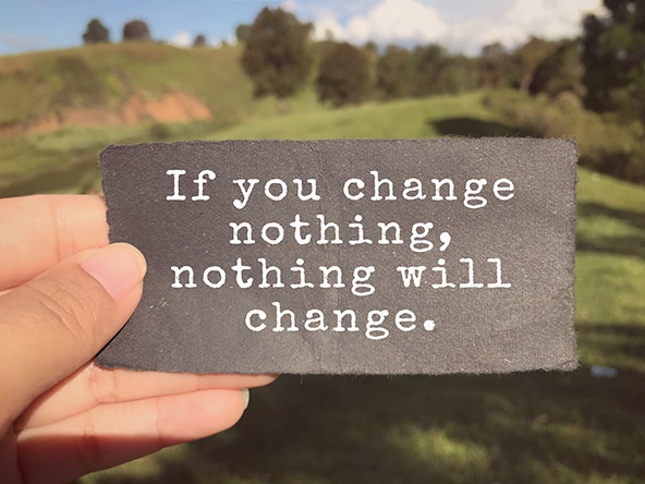 hand holding a small card that says: If you change nothing, nothing will change