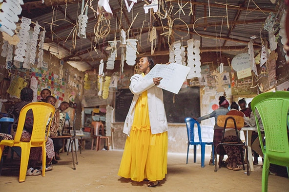 teacher wearing a yellow dress in a classroom in Ethiopia