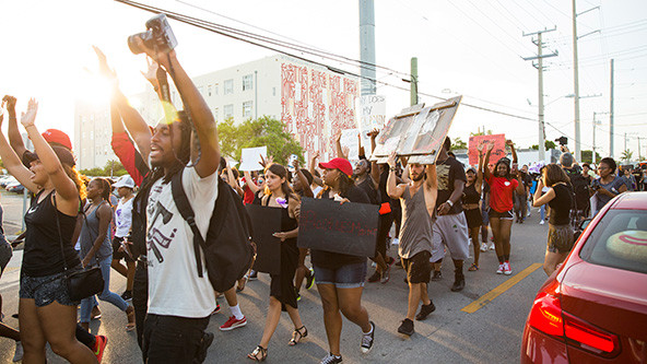 Group of peaceful protestors holding Black Lives Matter related signs march on the streets of Miami.