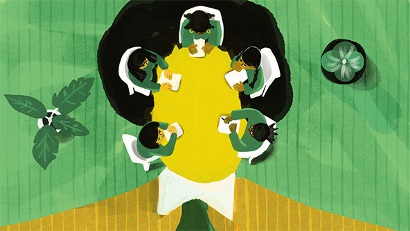 People sitting at a board room table that's in the shape of a human head