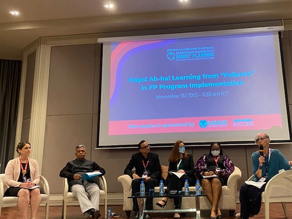 Five people sitting on a stage having a discussion