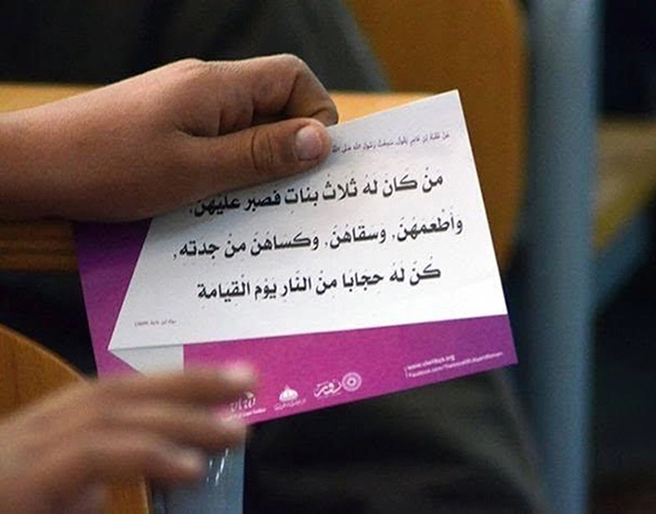 Hand holding flyer with words in Arabic