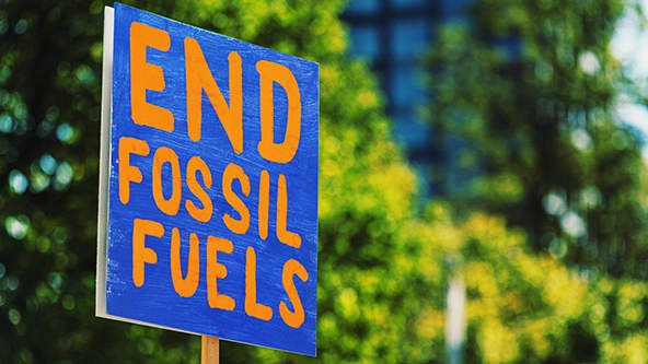 A blue and orange protest sign that says 