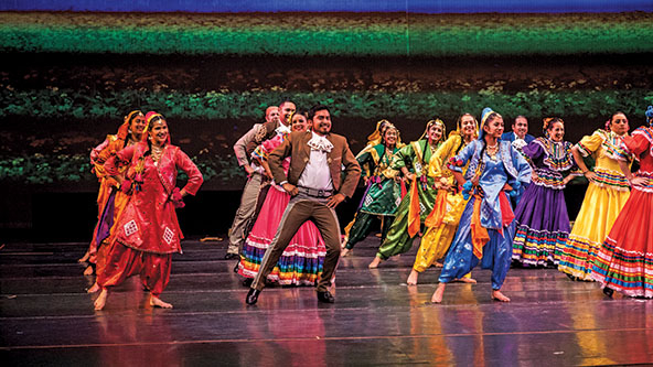 Indian and Mexican traditional folk artists dancing in colorful costumes on a stage