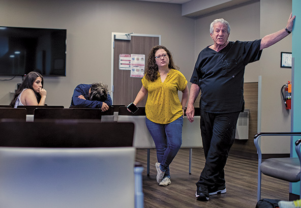 A doctor and women's health clinic workers stand in the waiting room of their clinic.