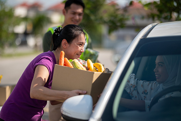 Volunteers giving out food at a food bank distribution site