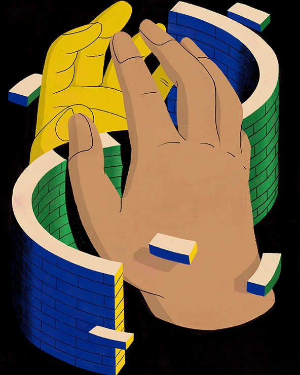 Hands reaching to touch fingertips over a curving brick wall