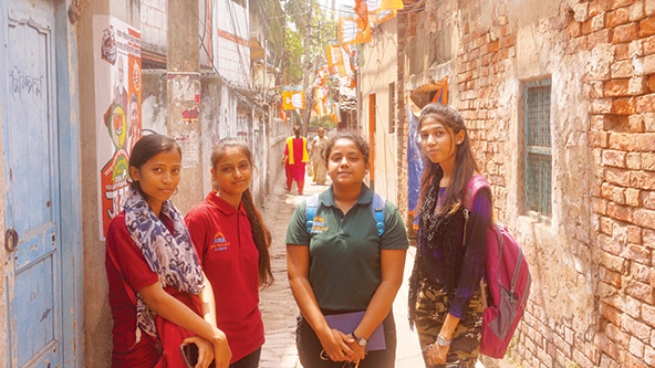 Four young people standing in a street, looking at camera