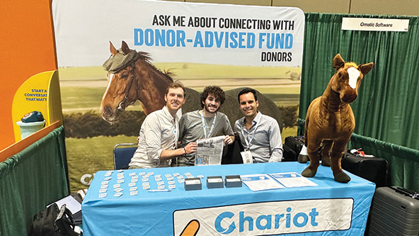 Three people sitting at a conference table with Chariot branding
