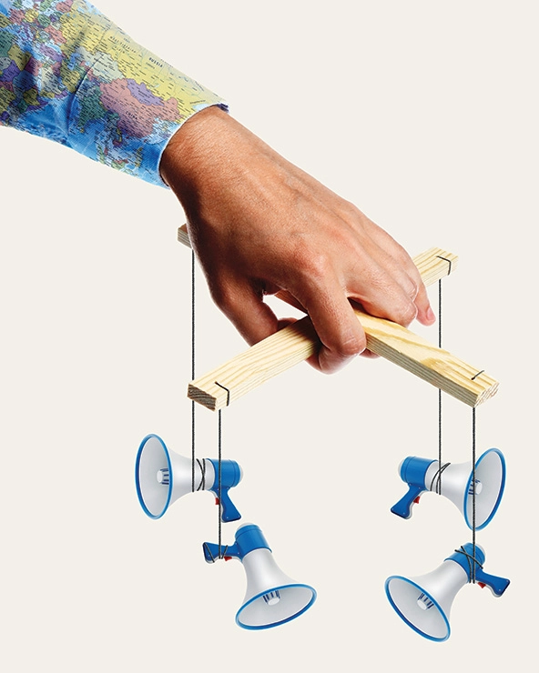 hand holding marionette strings with bullhorns attached to them