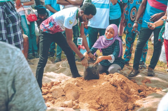 a teacher shows farming techniques to young people