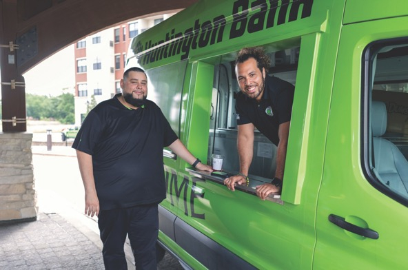 two men in and by a mobile coffee shop in a van