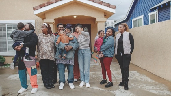 family stands in front of an airbnb home they stayed in