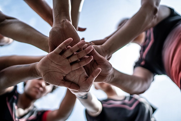 Close-up of female soccer team stacking hands in the field stock photo