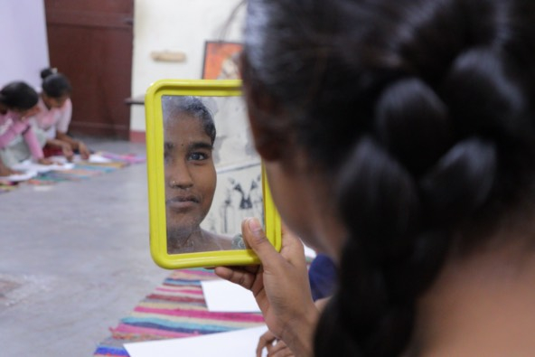 photo of a girl looking at herself in a hand mirror