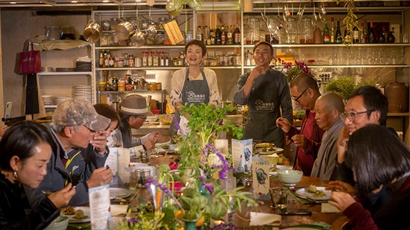 People sitting around a dining table with a meal before them