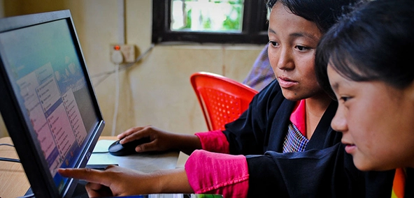 Two young woman looking at a computer screen