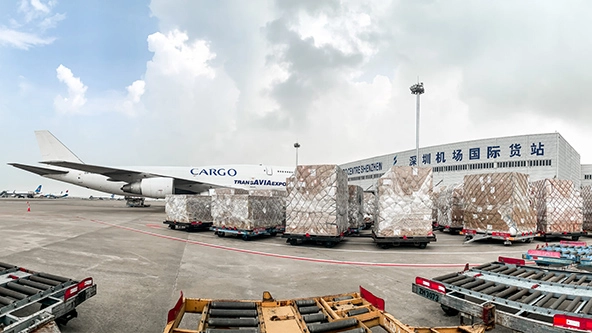 Boxes of PPE on a runway with an airplane.
