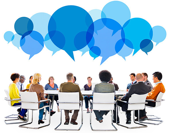 Diverse group of people sitting around a table with speech bubbles overhead