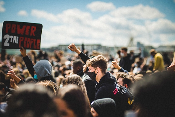 A white protester showing support by raising his fist for the Black Lives Matter demonstration in Cologne, Germany.