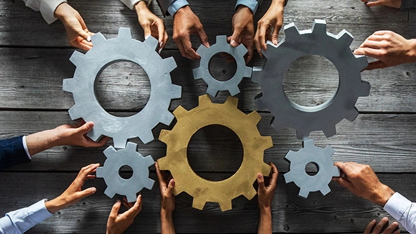 Hands holding gears together to symbolize collaboration