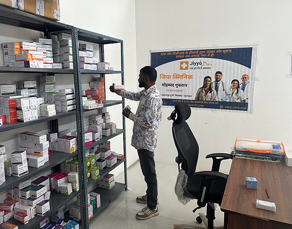 Pharmacist standing with shelves of medicines
