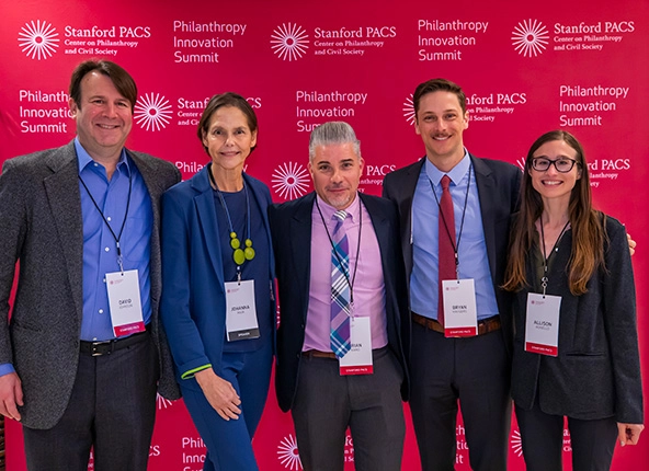 three men and two women smiling at camera