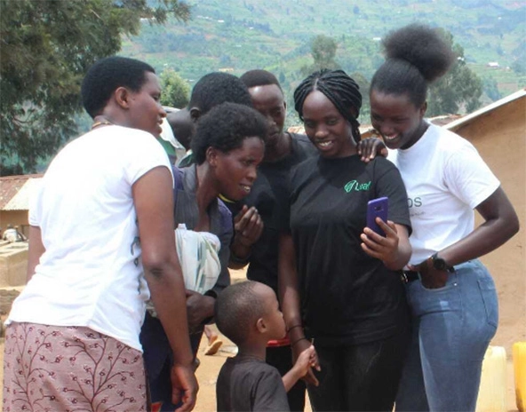 A group of women looking at a cell phone.