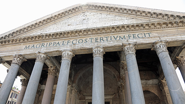 Wide facade of very ancient building with Roman lettering