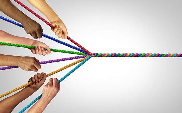 hands pulling six pieces of a braided rope