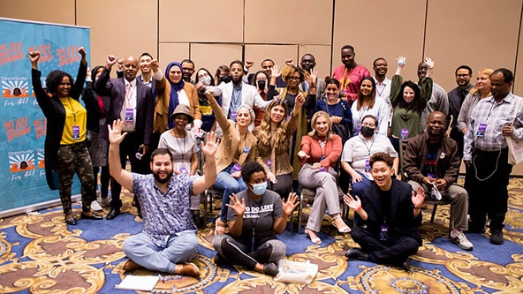 Thirty people gathered together for a photo in a conference room.