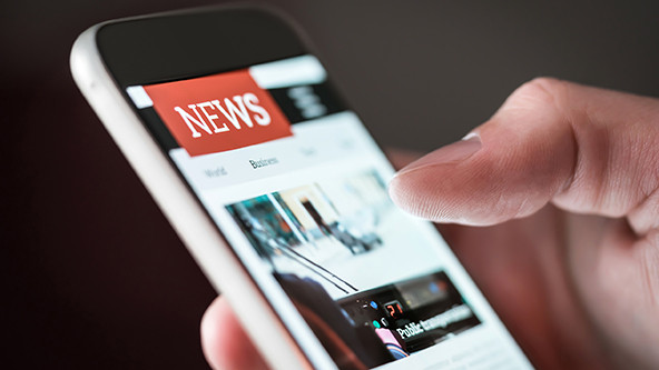 thumb scrolling through mobile news application on a smartphone