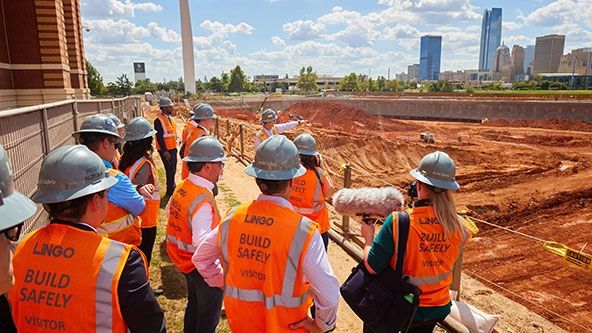 People in hardhats looking at a construction site.