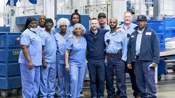 two rows of workers in uniforms facing camera