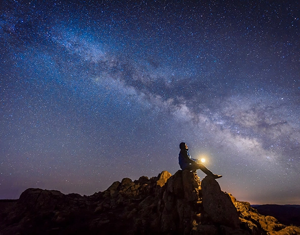 man looking up at the milky way galaxy